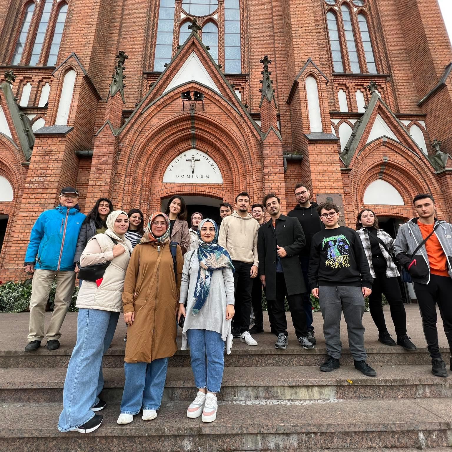 Students posing on the steps in front of a church during a city tour of Siedlce.