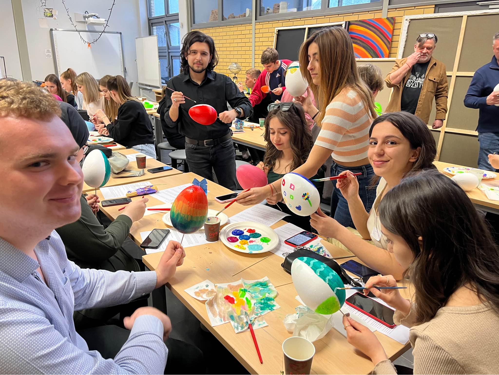 Students painting Easter eggs during a workshop on holiday traditions.
