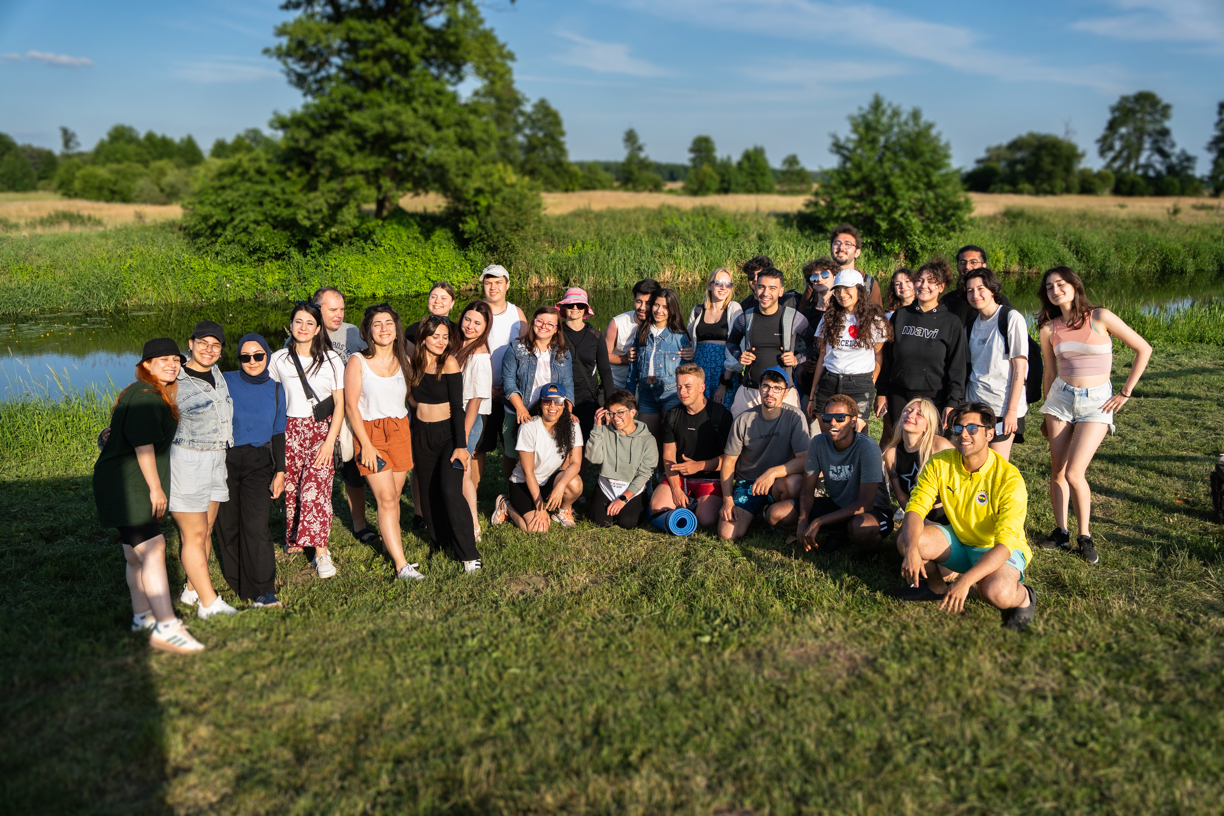 A group of students posing for the photo on a riverbank before the trip.